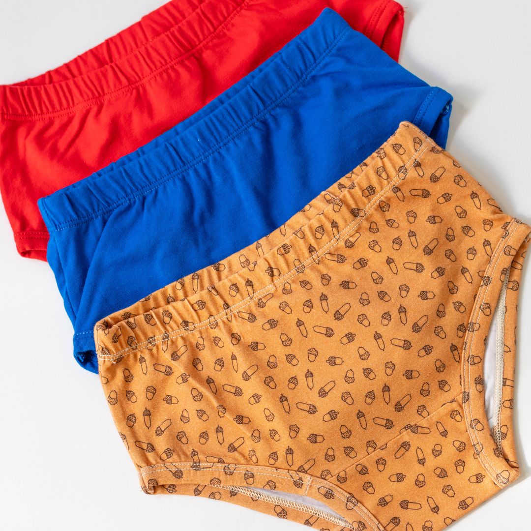 "Back-to-School Pack"—a set of three organic cotton undies for girls, perfect for the school year. Featuring a mix of versatile solid colors and a fun acorn print, this collection offers a blend of style, comfort, and durability for daily wear.

